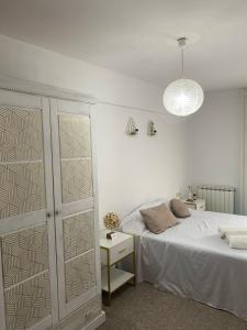1 dormitorio con 1 cama, armario y lámpara en La Mirada de Monreal, en Monreal del Campo