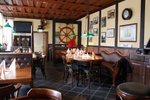 a restaurant with tables and chairs and a clock on the wall at Zum Alten Schifferhaus in Lauenburg
