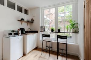 a kitchen with a counter and two stools at Charming Large Studio in Hampstead in London