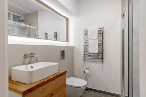 a white bathroom with a sink and a toilet at Charming Large Studio in Hampstead in London