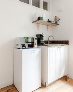 una cocina con armarios blancos y fregadero en Charming Large Studio in Hampstead, en Londres