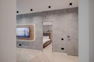 a bedroom with a bed and a tv on a wall at CHANTTAL Luxury - BOUTIQUE in Bucharest