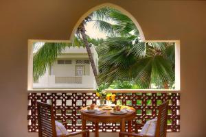 um quarto com uma mesa e uma palmeira em Diamonds Dream of Africa em Malindi