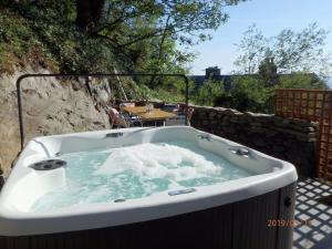 a jacuzzi tub on a patio with a table at Bryn Mair in Barmouth in Barmouth