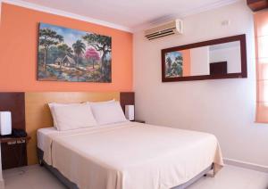 um quarto com uma cama branca e uma parede laranja em Hotel By Armonía Santa Cruz em Santa Cruz de la Sierra