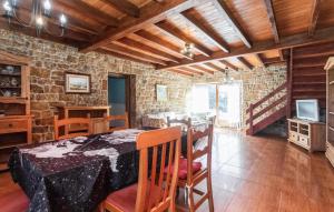 Un comedor con una mesa y una pared de piedra. en 5 Bedroom Nice Home In Arguero, en Argüero