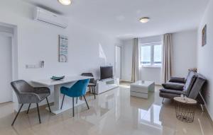 ein weißes Wohnzimmer mit einem Tisch und Stühlen in der Unterkunft Lovely Apartment In Tribanj With Kitchen in Šibuljina