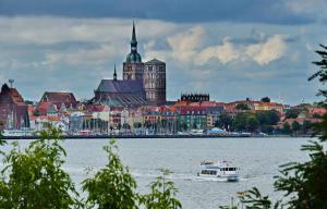 a boat in the water in front of a city at Ferienwohnung Sundüberblick in Altefähr