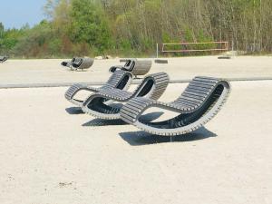 una fila de sillas sentadas en la arena en una playa en Ferienwohnung Sundüberblick, en Altefähr