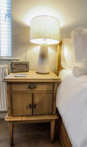 a lamp on a night stand next to a bed at Sea Spray - Bracklesham Bay in Chichester