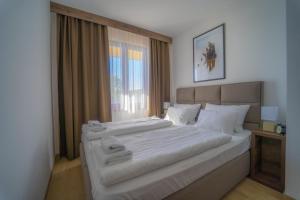 a large white bed in a room with a window at Casa D Argento in Veliko Gradište