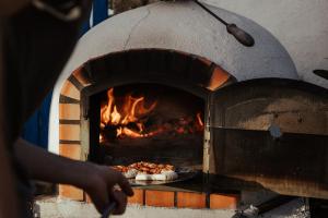 a person is cooking food in an oven at João Jungle in Açafora