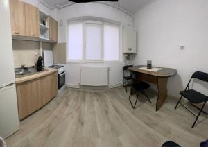 eine Küche mit einem Tisch und einem Schreibtisch darin in der Unterkunft Enjoy Apartment Barlad in Bîrlad