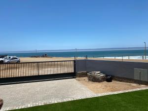 a view of a beach with a car and the ocean at DieStrandwolf Sea View Self Catering in Hentiesbaai