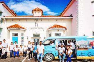 un groupe de personnes debout devant un bus dans l'établissement Hospitality Expert Stonehenge - 5BR Mansion, à Montego Bay
