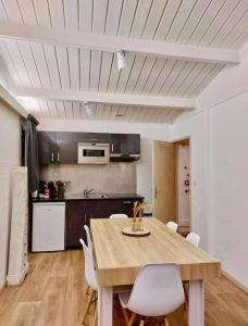 een keuken met een houten tafel en witte stoelen bij Village de vacances d'Oignies in Petit Mesnil