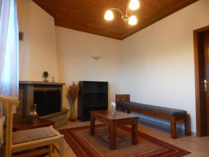 a living room with a bench and a tv at Παραδοσιακός Ξενώνας Αετορράχης - Aetorrachi's Traditional Guesthouse 