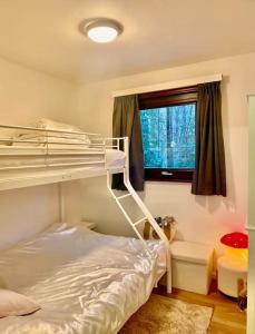 een slaapkamer met een stapelbed en een raam bij Village de vacances d'Oignies in Petit Mesnil