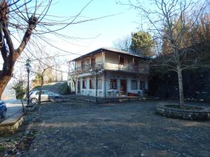 an old house with a car parked in front of it at Παραδοσιακός Ξενώνας Αετορράχης - Aetorrachi's Traditional Guesthouse in Aëtorráchi