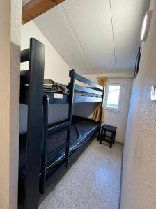 een kamer met stapelbedden in een kleine kamer bij Bel appartement avec place de parking privée, piscines in Vendres