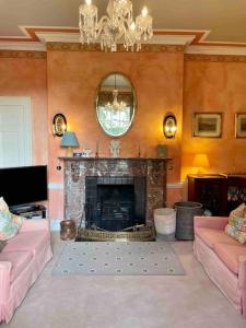a living room with a fireplace and a mirror at Marlacoo House Luxury Georgian home in Portadown