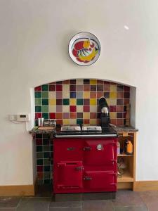 a red stove in a kitchen with a tiled wall at Marlacoo House Luxury Georgian home in Portadown