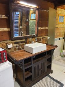 uma casa de banho com um lavatório e um espelho em Chalés Catavento em Maresias