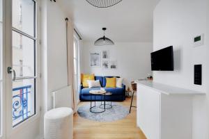 uma sala de estar com um sofá azul e uma televisão em Amazing Residence Cremieux Gare de Lyon em Paris