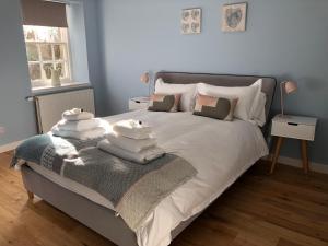a bedroom with a bed with towels on it at Jasmine Cottage, sleeps 6 near Elie, with garden in Fife
