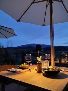 einen Tisch mit zwei Gläsern Wein und Teller mit Speisen in der Unterkunft B&B Le Sud in Entrechaux