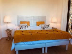 una camera da letto con un grande letto con lenzuola e cuscini arancioni di La Coulina a Nizza Altre 30 foto