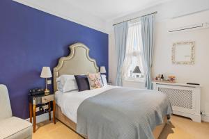 a bedroom with a bed with a blue wall at Kingston House in Torquay