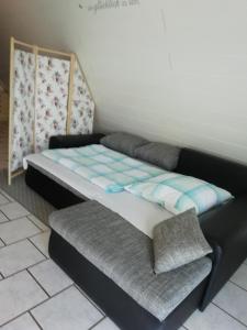 a bed and a chair in a room at Ferienwohnung Familie Faath in Bellheim