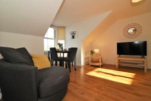 a living room with a couch and a television at Signature - No 11 Bonnet Apartments in Lanark