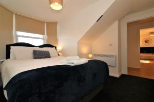 a bedroom with a large bed with white sheets at Signature - No 11 Bonnet Apartments in Lanark