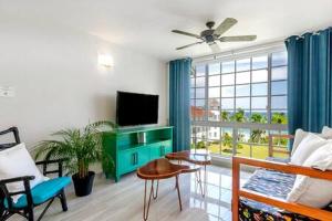 a living room with a flat screen tv and a couch at Ultra Modern 2BR Penthouse, Sleeps 5, Beach Front, Pool, Roof Patio, Montego Bay in Montego Bay