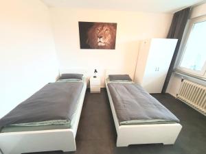 2 camas en una habitación con una foto del león en la pared en Kraftmensch Oberhausen 3 Schlafzimmer, Balkon, en Oberhausen
