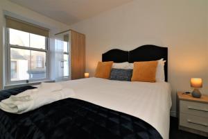 a bedroom with a large white bed and a window at Signature - No 5 Bonnet Apartments in Lanark