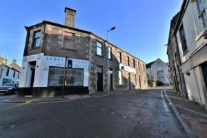 an empty street with an old brick building at Signature - No 1 Bonnet Apartments in Lanark