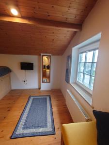 a living room with a large window and wooden ceilings at Fern Cottage Annexe in Croyde