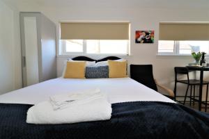 a bedroom with a large white bed with yellow pillows at Signature - No 3 Bonnet Apartments in Lanark