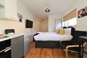 a small bedroom with a bed and a kitchen at Signature - No 3 Bonnet Apartments in Lanark