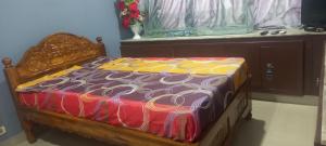 a bed with a colorful comforter and a window at River view nectaar estates in Rājahmundry
