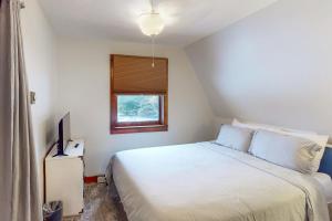 een slaapkamer met een wit bed en een raam bij Rock Stream Sanctuary in Rock Stream