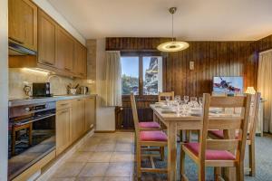 a kitchen with a wooden table and chairs and a dining room at Appartement LaForet 35 in La Tzoumaz +11 photos