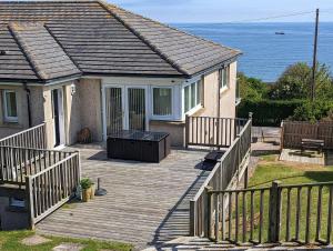 a house with a wooden deck next to the ocean at Elmbank house in Spittal