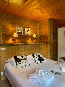 a bedroom with a large bed with wooden walls at Chalet Hôtel du Mont-Charvin & Spa in Crest-Voland