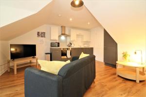 a living room with a couch and a kitchen at Signature - No 7 Bonnet Apartments in Lanark