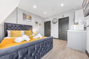 um quarto com uma cama grande com almofadas amarelas e brancas em Captivating Serviced Room Sydenham London SE26 em Londres