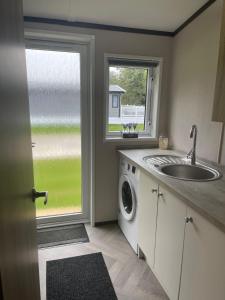 a kitchen with a sink and a washing machine at Ailsa Lodge with Hot Tub in York